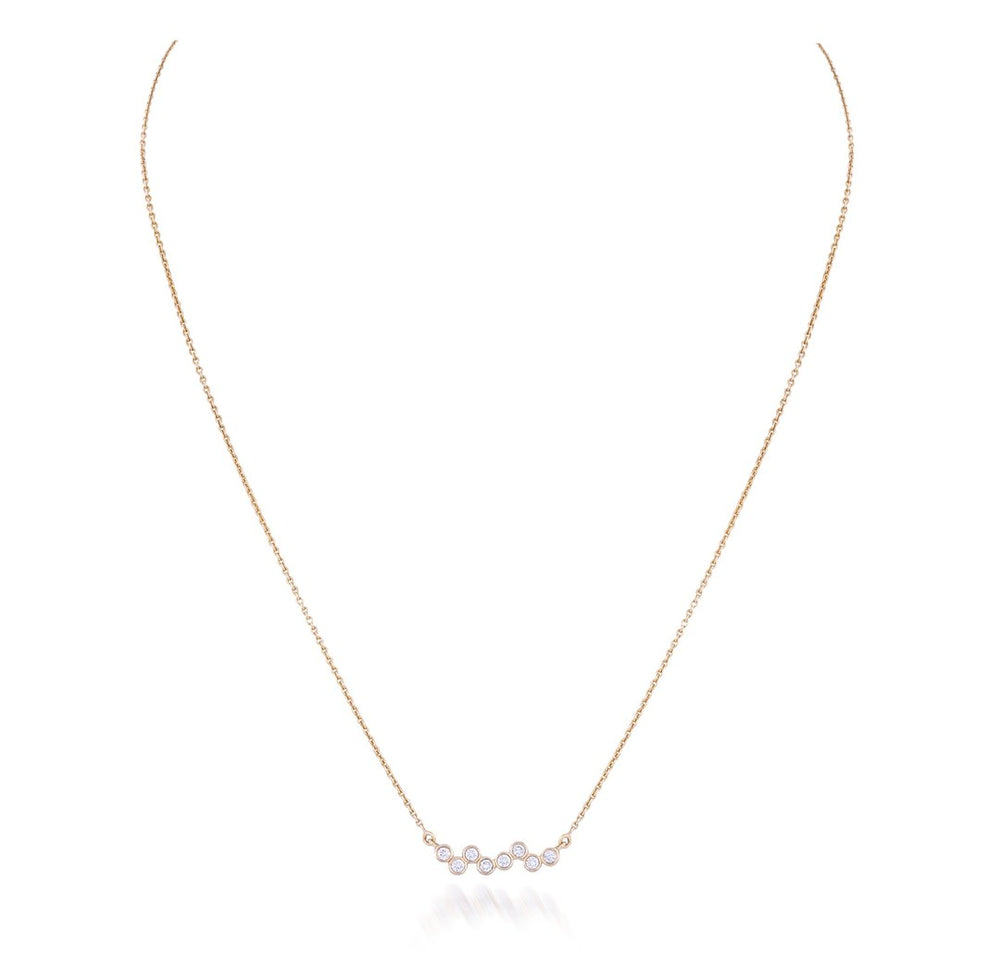 A delicate rose gold chain necklace featuring a small central cluster of iridescent, pearl-like beads, displayed on a clean white background with a soft reflection.
