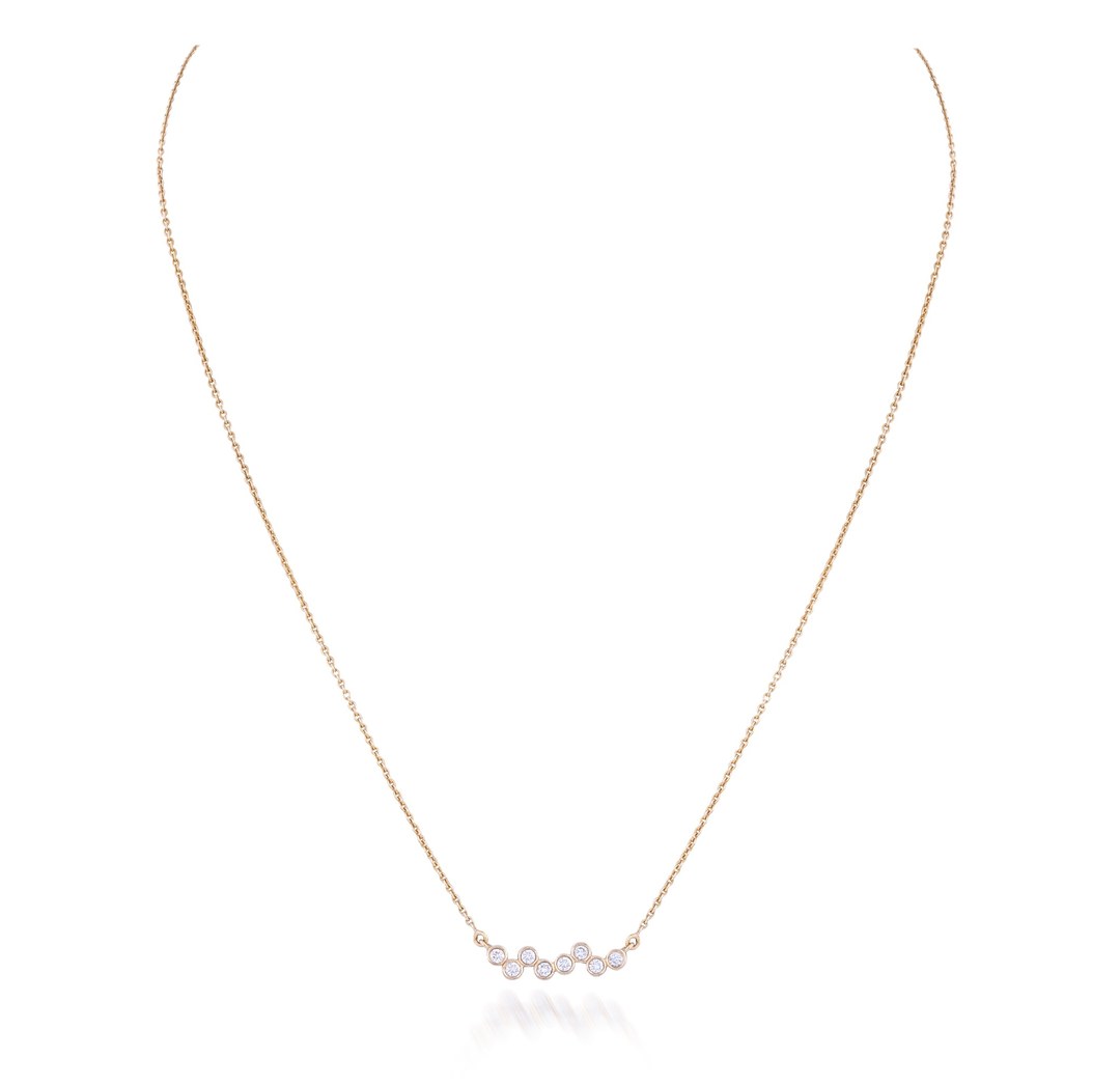 A delicate rose gold chain necklace featuring a small central cluster of iridescent, pearl-like beads, displayed on a clean white background with a soft reflection.