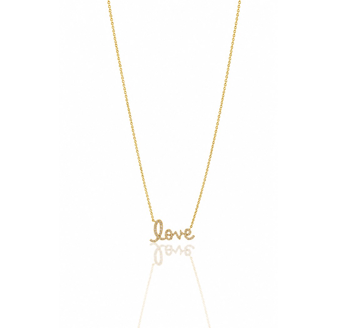 A delicate gold chain necklace featuring a small cursive pendant spelling 'love', displayed against a clean white background with a soft reflection below.