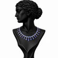 A statement necklace with blue baguette and round crystals set in silver-toned metal, displayed on a black female bust against a white background.
