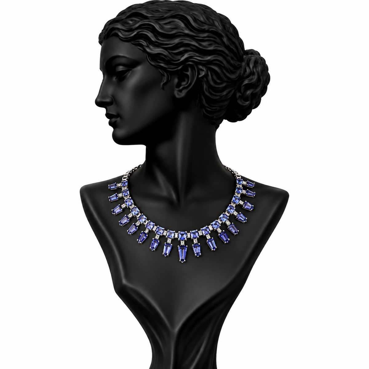 A statement necklace with blue baguette and round crystals set in silver-toned metal, displayed on a black female bust against a white background.